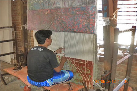 Weaver in Nepal weaving 5Under40 Rug