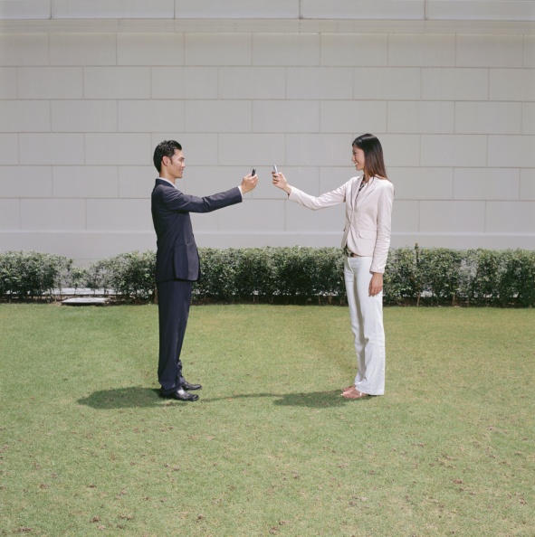 two people using cell phones facing each other