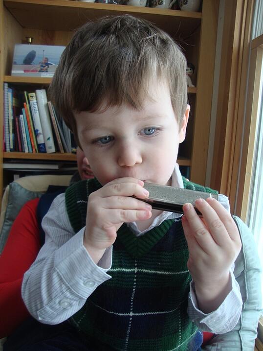 toddler playing harmonica