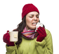 photodune-5866039-sick-woman-wearing-winter-clothing-blowing-her-sore-nose-and-holding-cup-of-hot-tea-on-white-xs