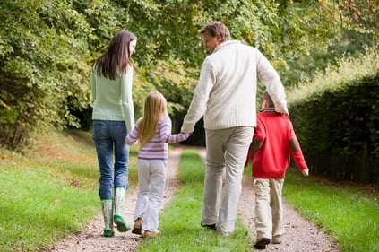 rear-view-of-family-walking-along-track-xs