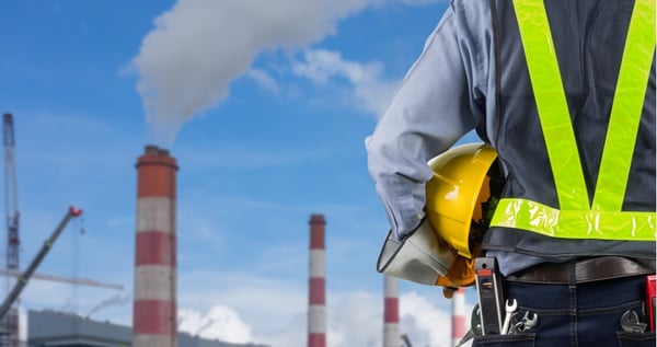 manufacturing worker holding his helmet