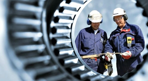 Two men working in a factory, investigating measurements