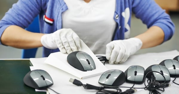 Person working in mouse making factory, packaging up mouse