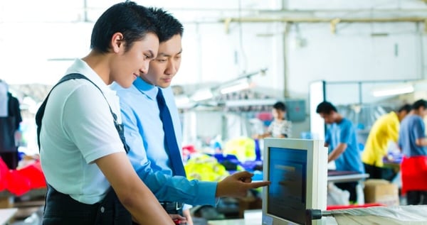 manufacturing operators pointing at a screen
