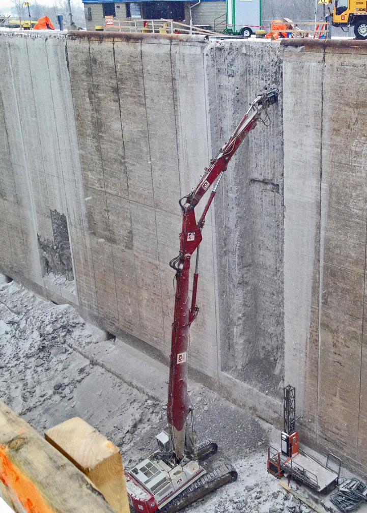 Long reach excavator concrete wall scaling