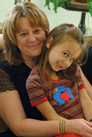 Mom holding smiling daughter in her lap