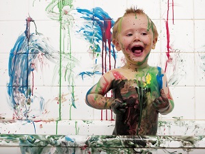 little boy making a mess with paint