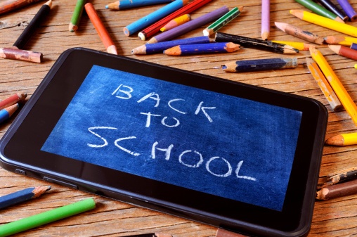 tablet surrounded by broken pencils with "back to school" written on it like a chalkboard