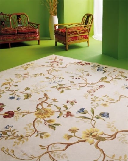 A cream, blue, red, yellow and green floral needlepoint rug in green living room with Chinoiserie and contemporary furniture
