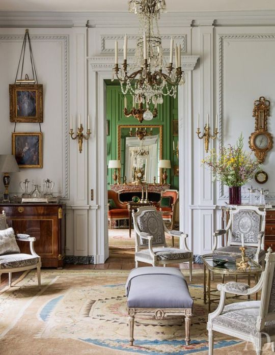 A beige and blue Neoclassical Aubusson rug paired with white walls and pale upholstery can create a modern atmosphere in a traditional French room as in the living room.