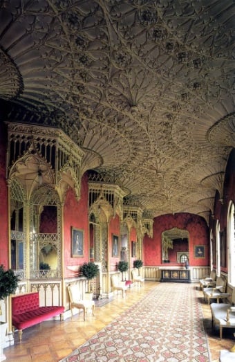Elizabethan needlepoint rug in cream, red, gold and charcoal complements ornate ceiling and red walls in the Grand Gallery, Strawberry Hill House, Twickenham, London