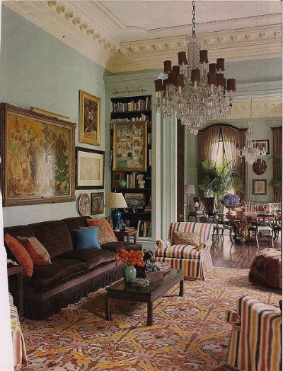  An antique red and gold damask needlepoint rugs complements green walls, brown silk sofa and and red, gold and blue striped upholstered chairs in a handsome English living room
