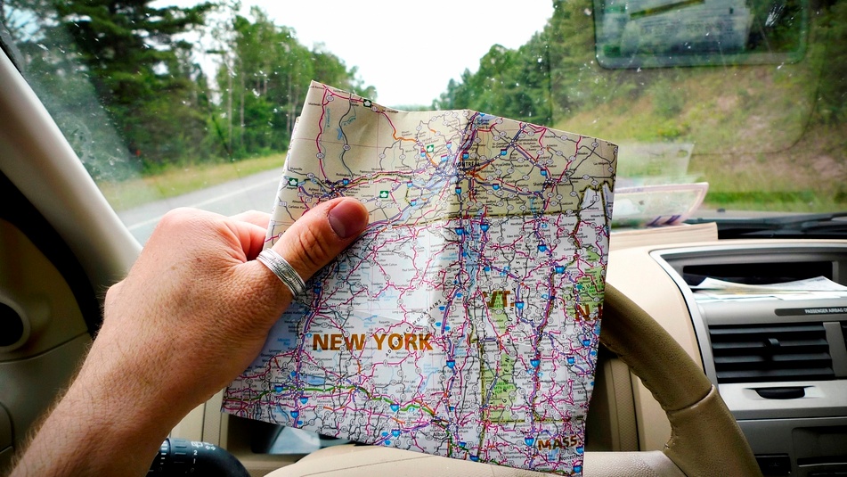 Person with map in car on roadtrip
