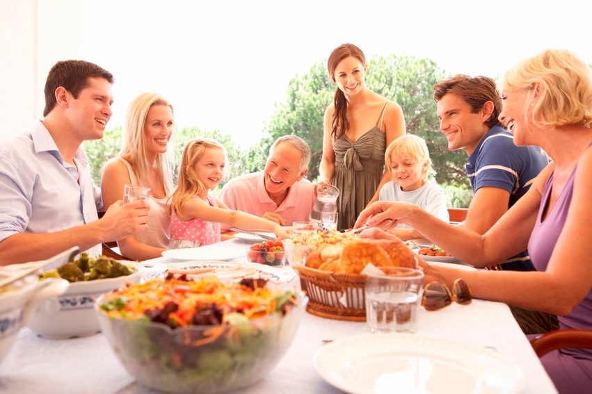 Multi generational family eats dinner outdoors al fresco