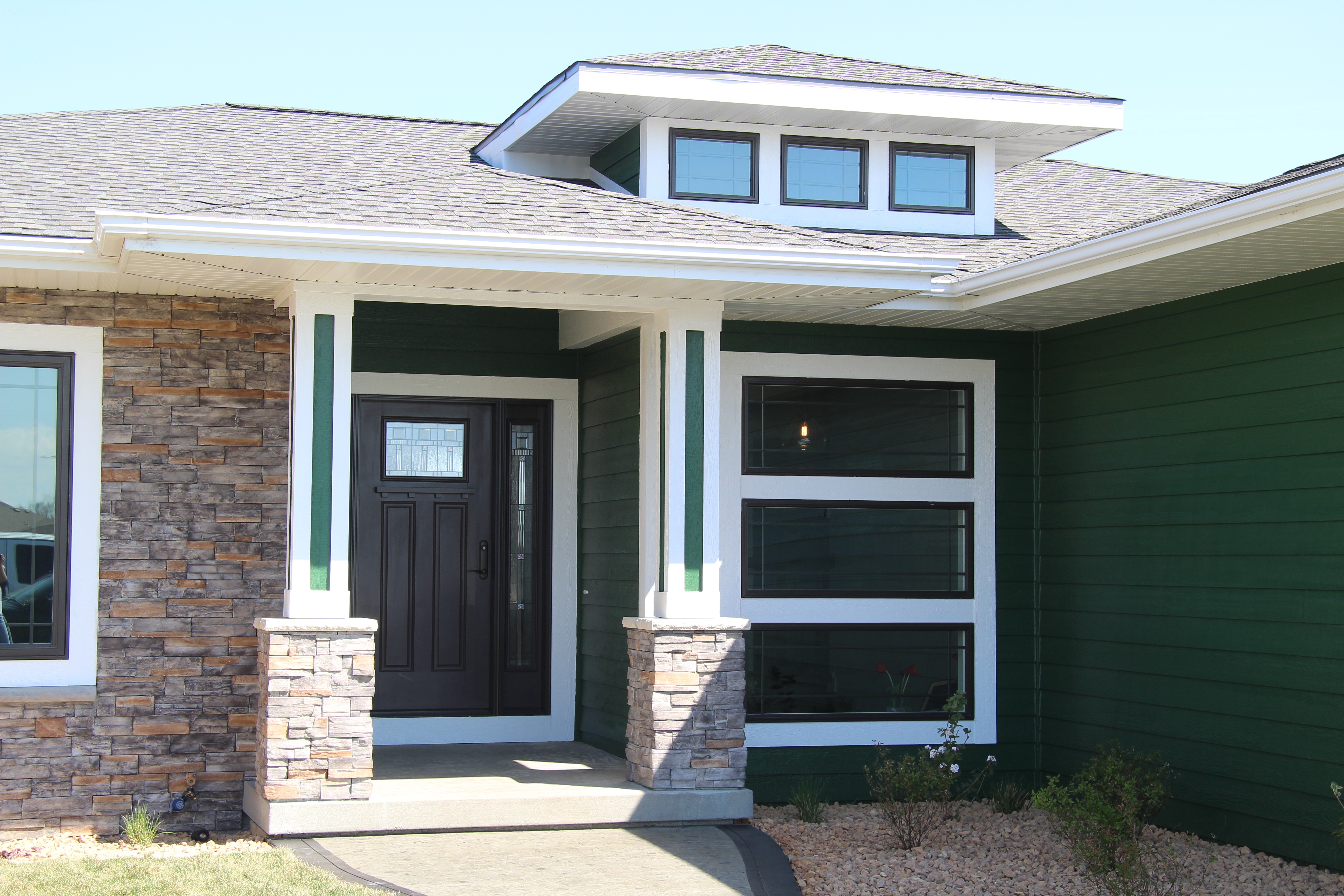 Green exterior front door and entryway of new home