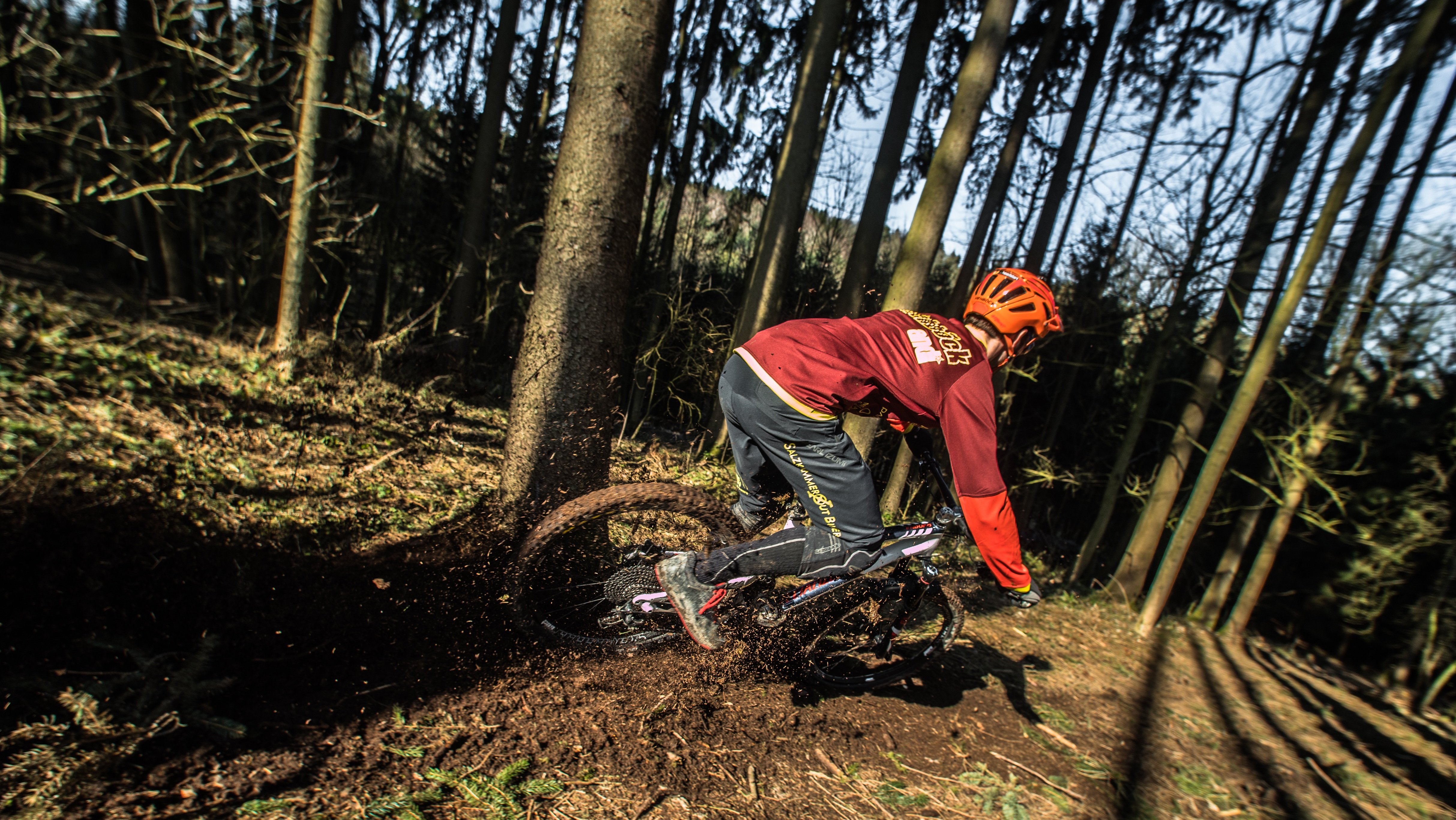 boy biking on a muddy trail in the woods