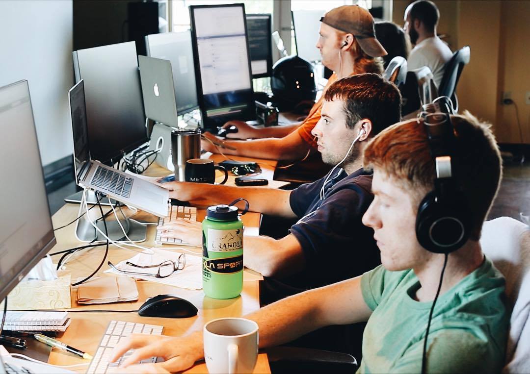 several mobile app developers working at their desks