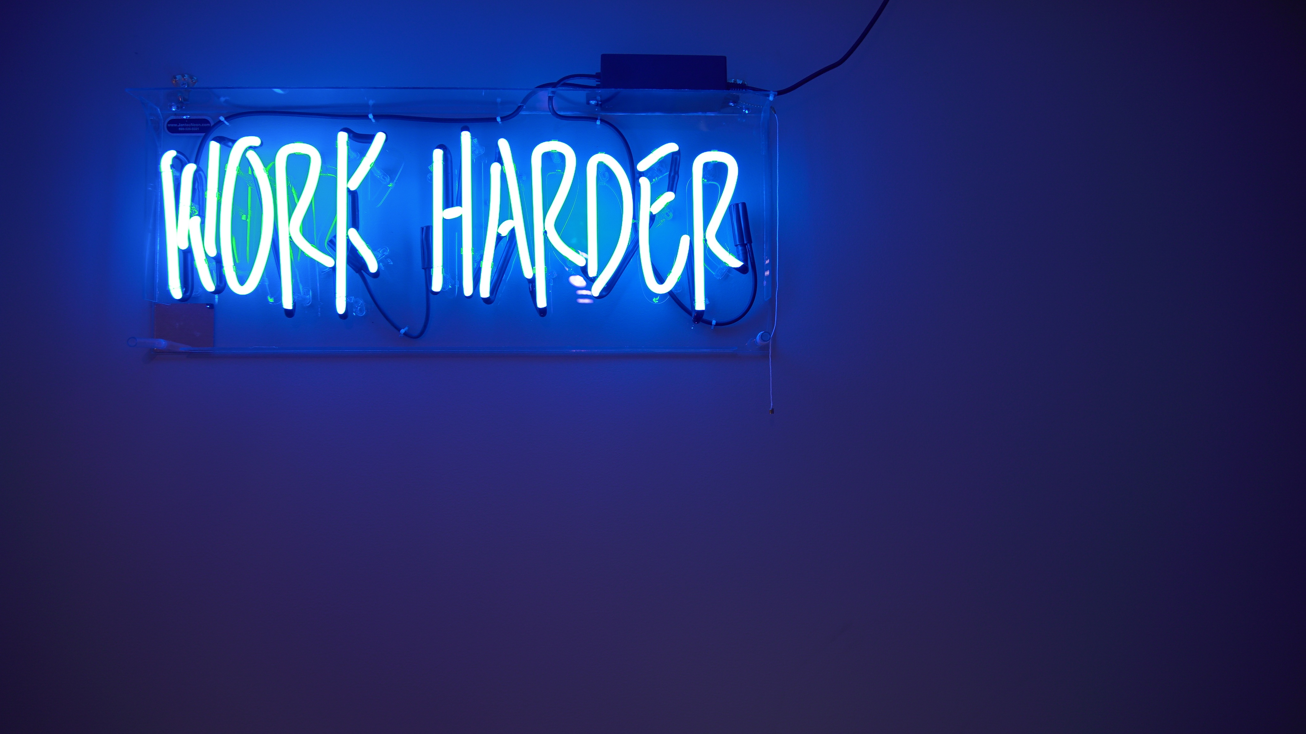 neon blue work harder sign