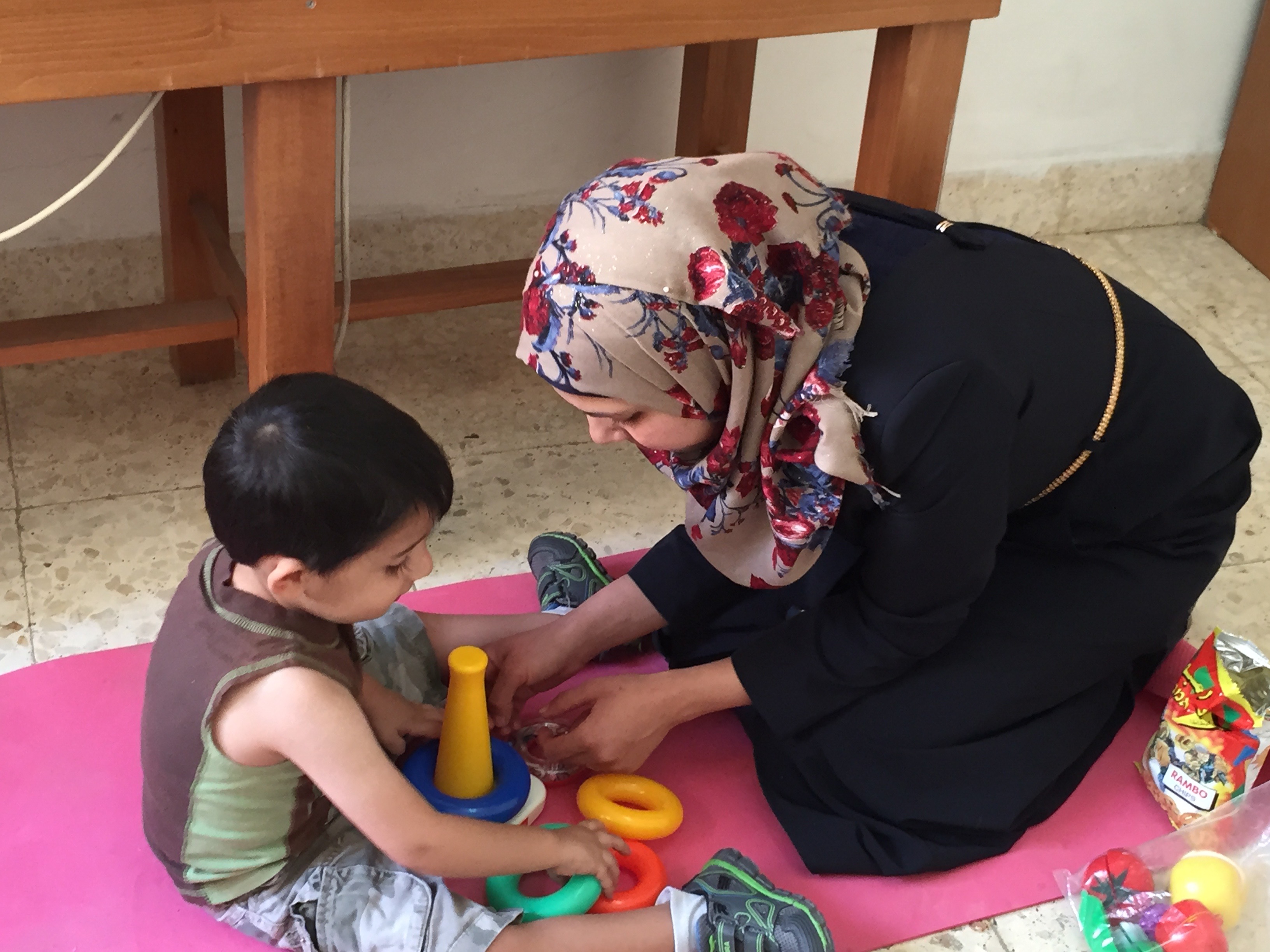 mother-helping-son-with-autism.jpg mother helping son with autism-play a game