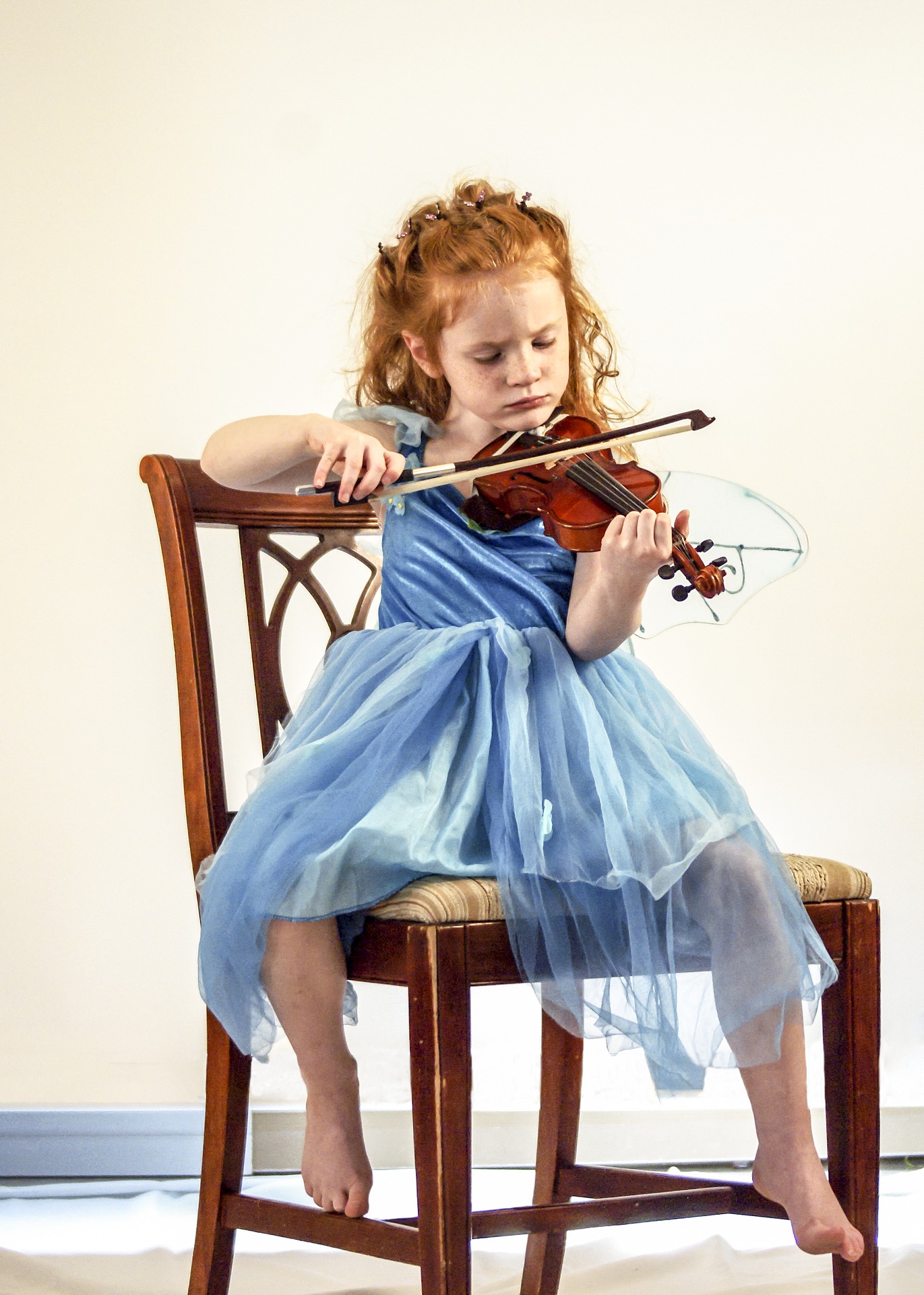 autistic girl playing violin during music lesson