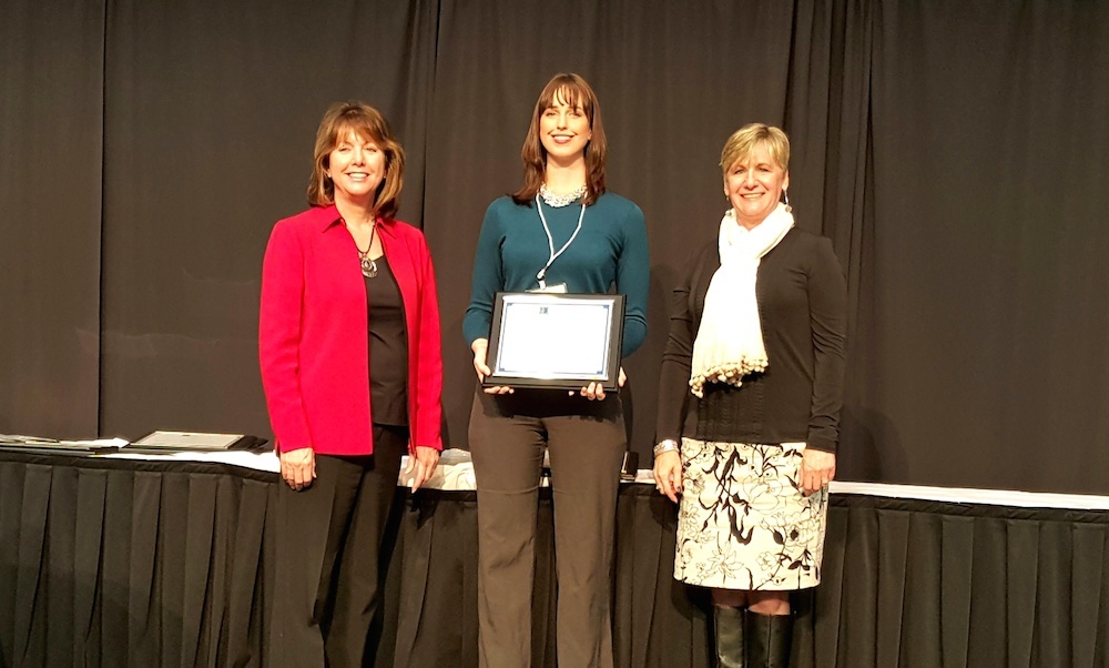 Whitney Slightham accepting award at International Economic Development Council conference in Alaska