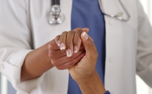 Close_up_of_female_African_American_doctor_holding_patients_hand