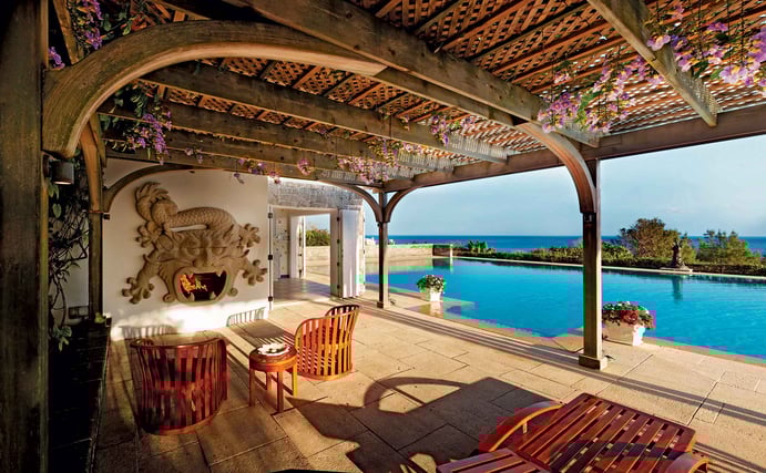A rare Chinese stone fireplace in the shape of a five-armed dragon forms the centerpiece of the pergola, which faces the infinity pool and the Atlantic Ocean beyond. A rare Chinese stone fireplace in the shape of a five-armed dragon forms the centerpiece of the pergola, which faces the infinity pool and the Atlantic Ocean beyond.