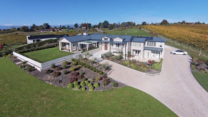 The award-winning design of this New Zealand estate is evident in a view that includes discreetly placed solar paneling and integrated landscaping of vineyards and orchards. The award-winning design of this New Zealand estate is evident in a view that includes discreetly placed solar paneling and integrated landscaping of vineyards and orchards.