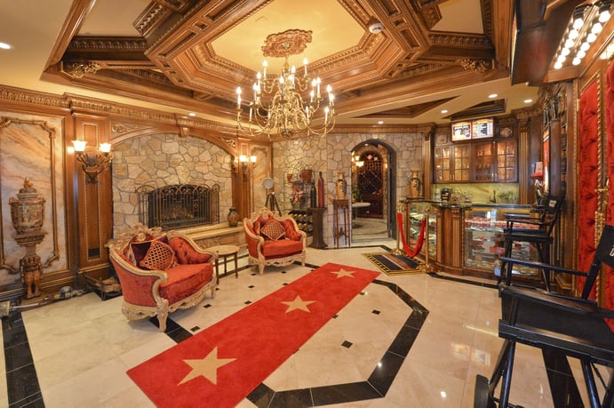 Framed by a beautiful Art-Deco inspired theater, this elegant home’s commercial-grade screen and projection system is valued at around $80,000. Wall sconces, Corinthian columns, and a decorative ceiling create an Old Hollywood atmosphere. Framed by a beautiful Art-Deco inspired theater, this elegant home’s commercial-grade screen and projection system is valued at around $80,000. Wall sconces, Corinthian columns, and a decorative ceiling create an Old Hollywood atmosphere.