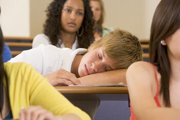 Teenage boy asleep in class.