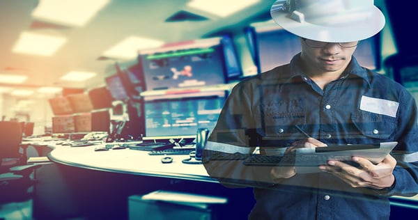 Technician working with tablet in a control room for monitor control process