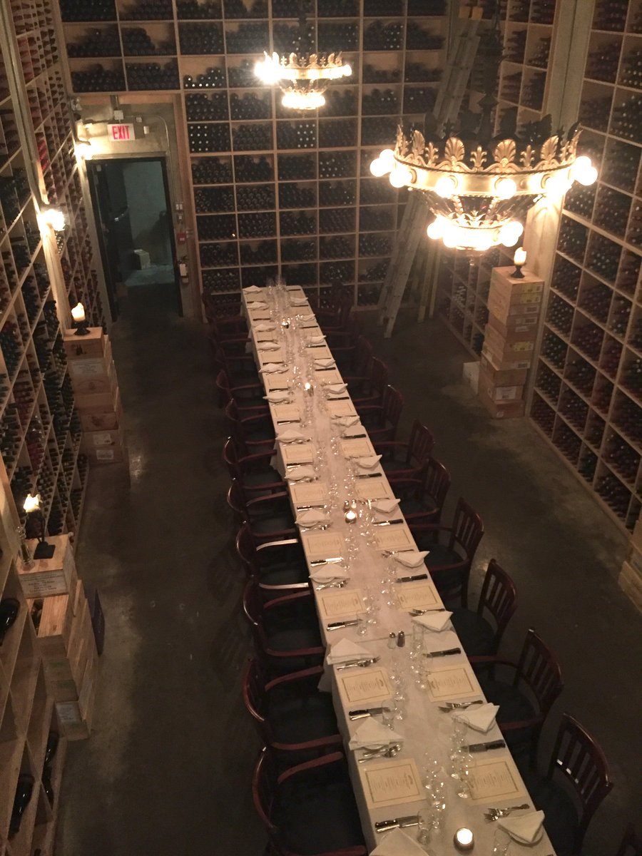Long table in wine cellar set-up with place settings