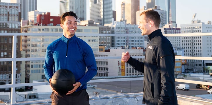 私人教练手持健身球与客户交谈