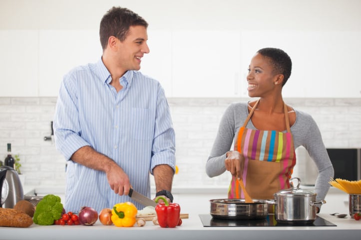 制作健康植物的两餐的两件素食主义者在厨房里