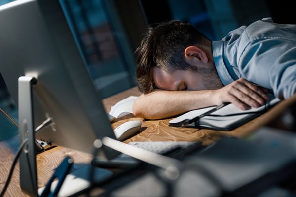 man falls asleep at computer station