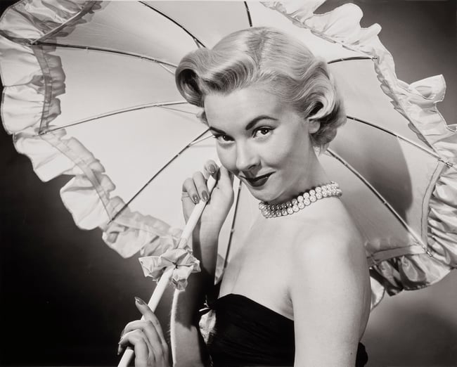 Black and white portrait of a young woman holding a parasol