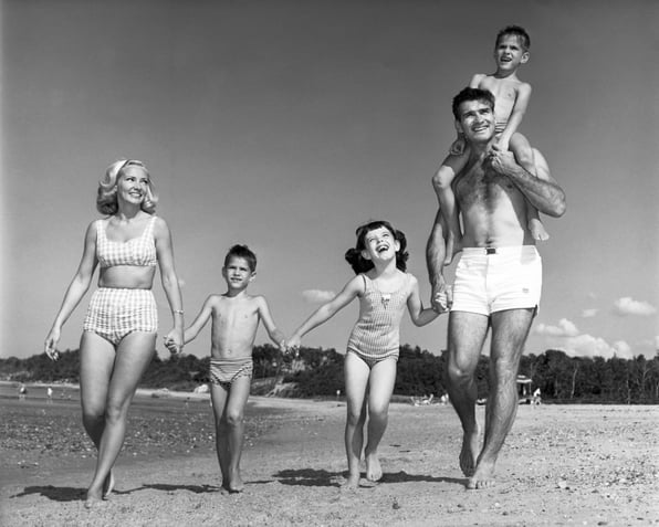Family with three kids walking on beach