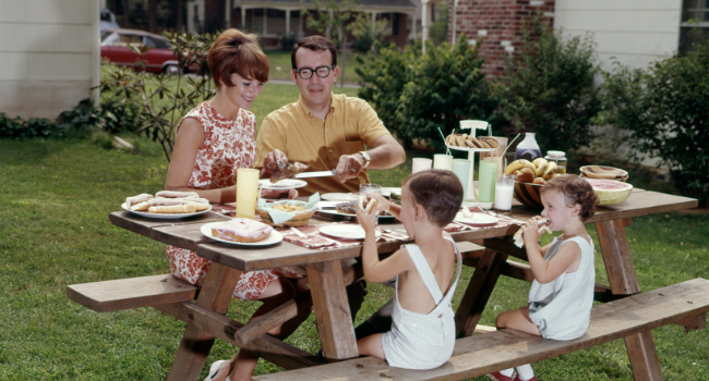 Stock image of a family sitting at a picnic table. 