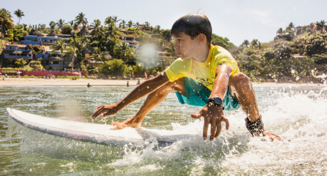 Young boy surfing in ocean