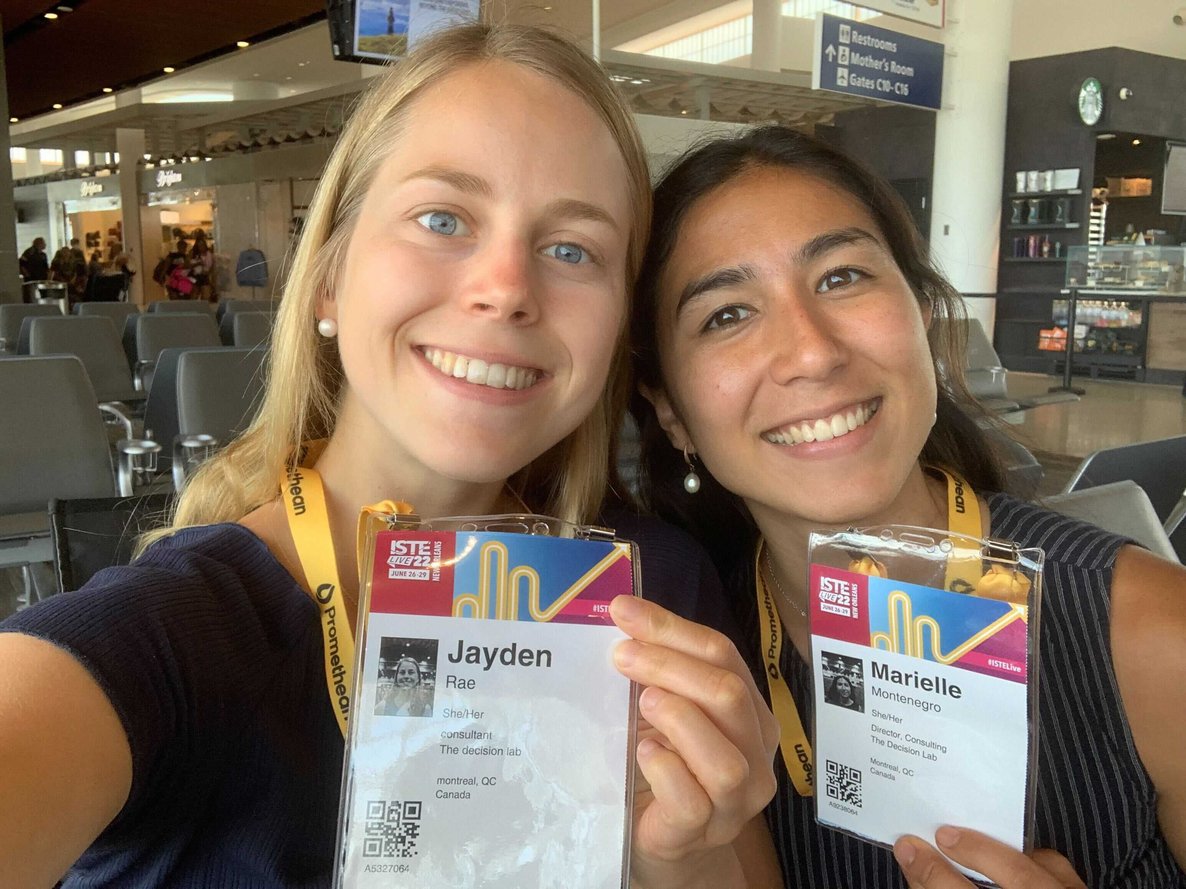 Two people smiling and holding laminated conference badges.