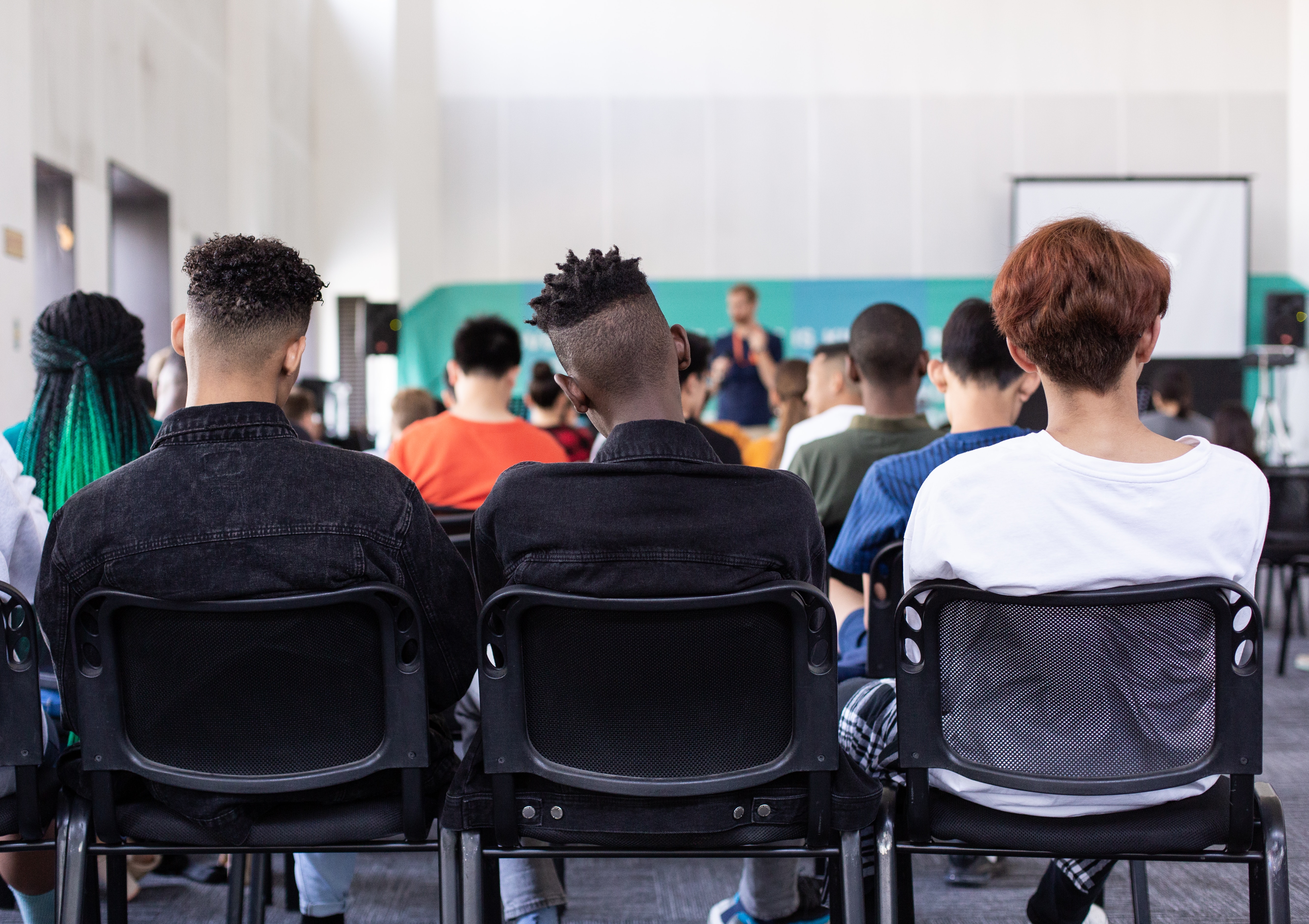 A classroom of students facing their teacher. 