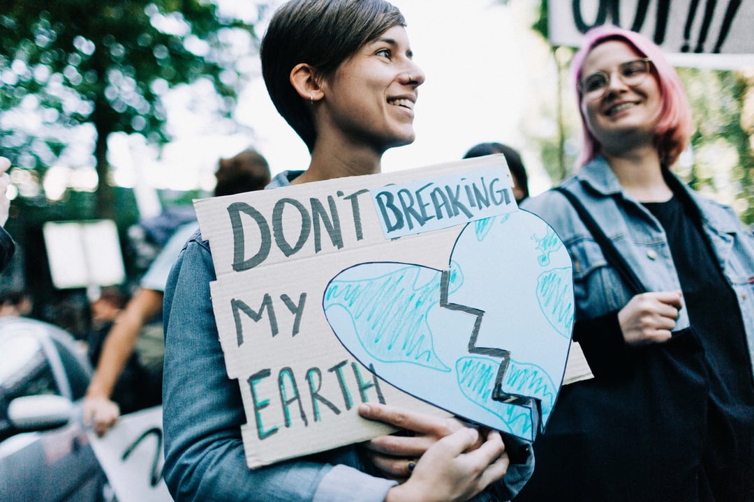 Frau mit Schild bei weltweitem Klimastreik