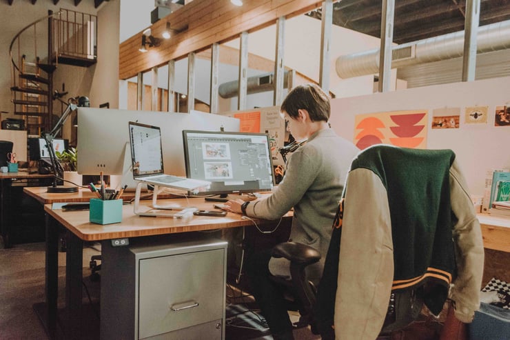 Woman designing on computers in a creative office space.