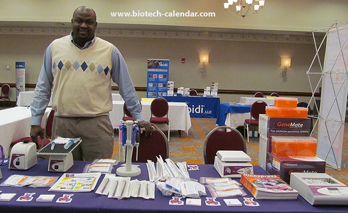 Life science technology exhibitor shows off his company's laboratory equipment.