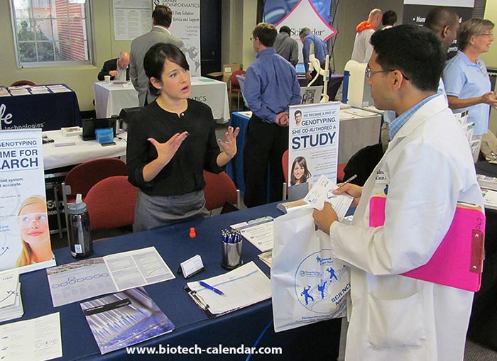 An exhibitor explains some new laboratory equipment to an up and coming scientist.
