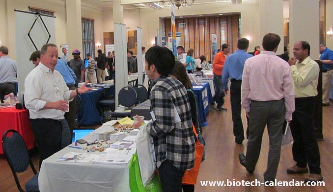 Exhibitors explain life science solutions to a researcher.