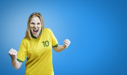 Brazilian woman celebrates on blue background with her face painted. Can be used as Australian uniform too.