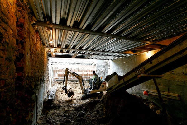 Using a conveyor belt to excavate a basement