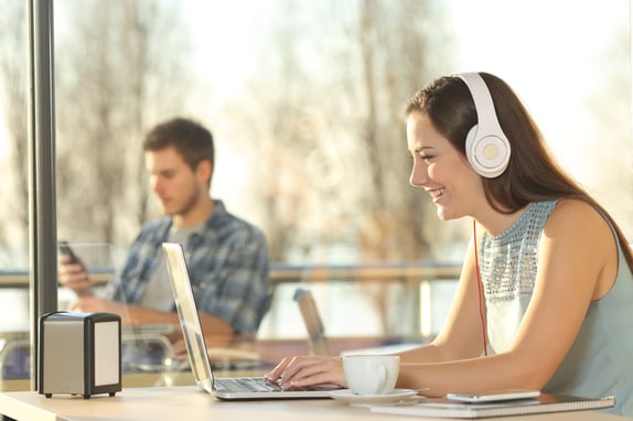 Woman wearing headphones and looking at laptop which conducting a focus group online